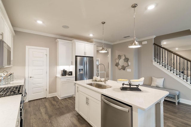 kitchen with stainless steel appliances, light countertops, hanging light fixtures, white cabinetry, and a sink