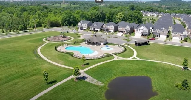 drone / aerial view featuring a residential view and a view of trees