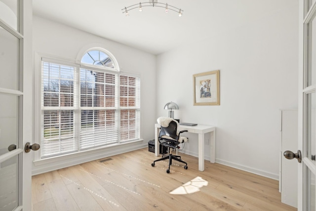 office featuring light wood-type flooring, visible vents, and baseboards