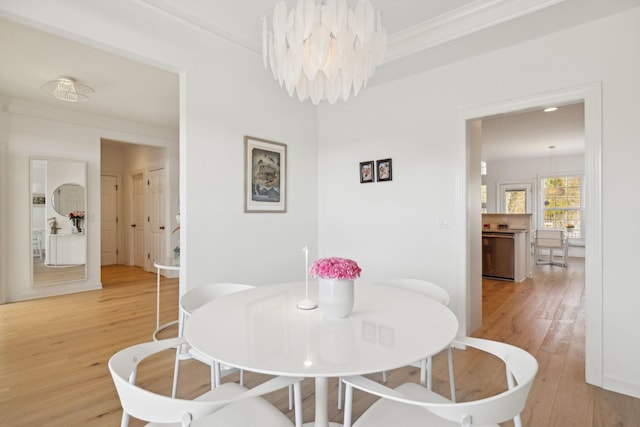 dining room featuring ornamental molding, an inviting chandelier, and wood finished floors