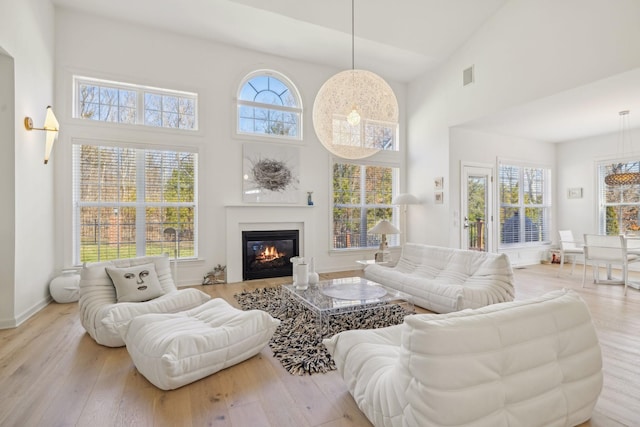 living area featuring light wood-type flooring, plenty of natural light, and visible vents