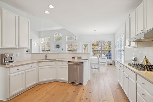 kitchen featuring stainless steel appliances, white cabinets, and decorative light fixtures