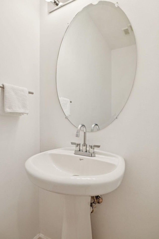 bathroom with visible vents, baseboards, and a sink