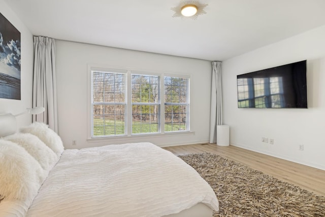 bedroom with baseboards and wood finished floors