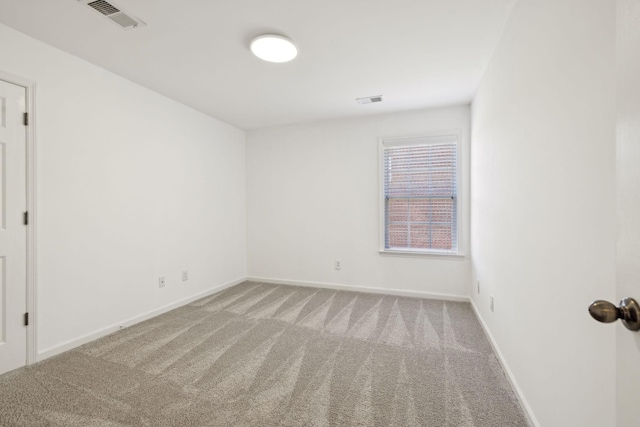 carpeted empty room with visible vents and baseboards