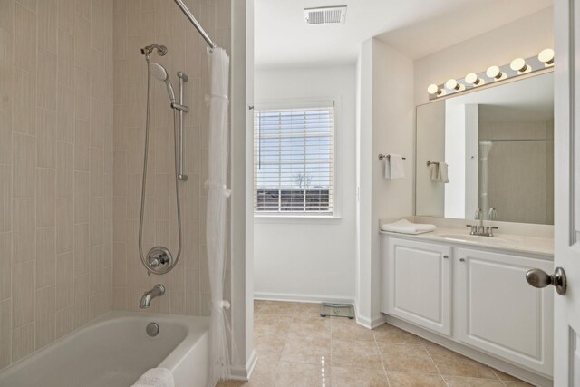 full bath featuring tile patterned flooring, vanity, visible vents, baseboards, and shower / bathing tub combination