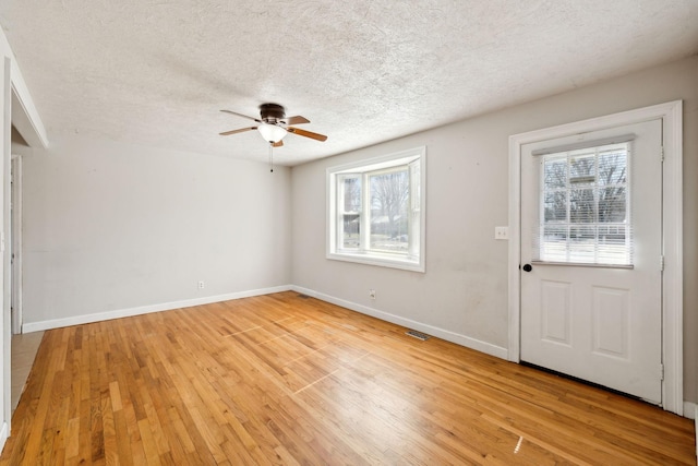 foyer featuring a healthy amount of sunlight, light wood-style flooring, visible vents, and baseboards