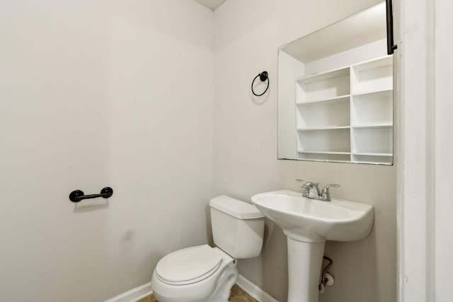 bathroom with baseboards and toilet