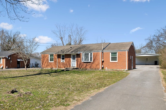 ranch-style home featuring aphalt driveway, a front yard, brick siding, and an attached carport