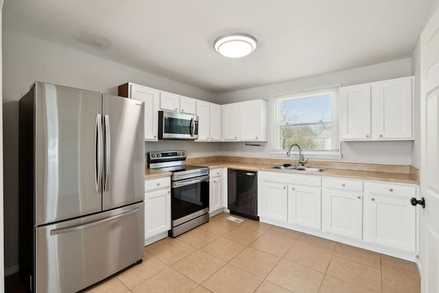 kitchen featuring light tile patterned floors, stainless steel appliances, light countertops, white cabinets, and a sink