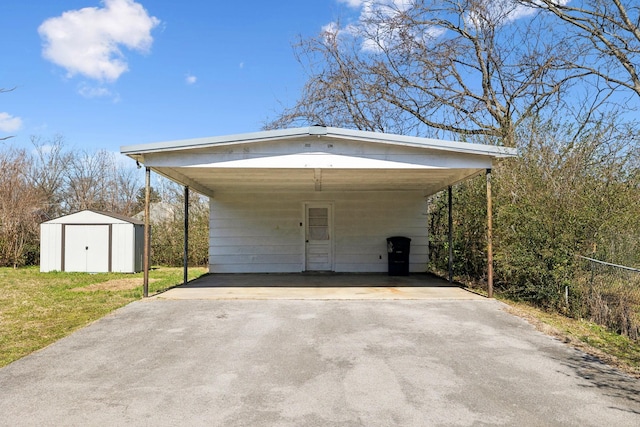 garage with a carport, a storage shed, and concrete driveway