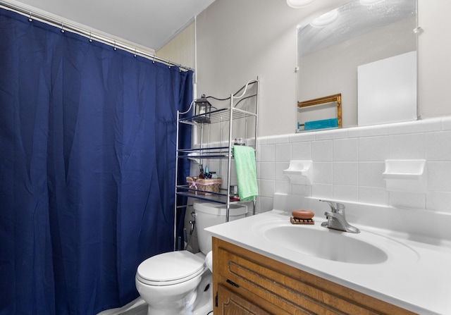 full bathroom with a wainscoted wall, vanity, toilet, and tile walls