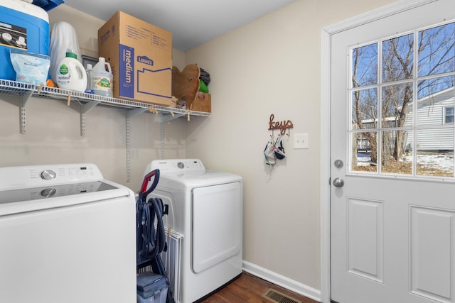 laundry area featuring laundry area, visible vents, dark wood finished floors, baseboards, and washing machine and dryer