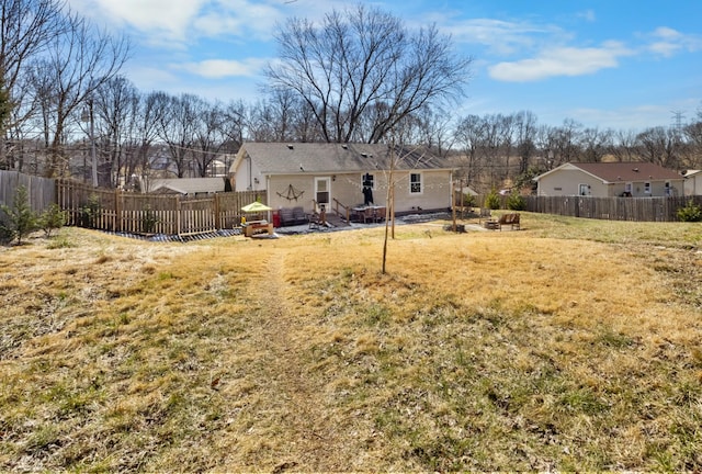 back of house featuring a lawn, a patio area, and a fenced backyard