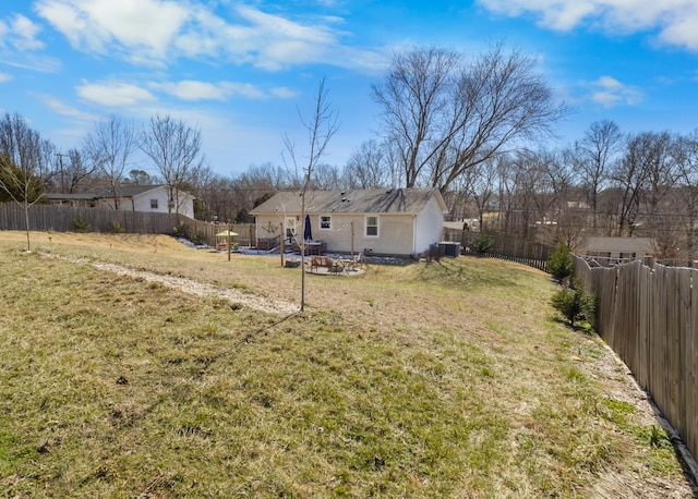 view of yard featuring a fenced backyard and central AC