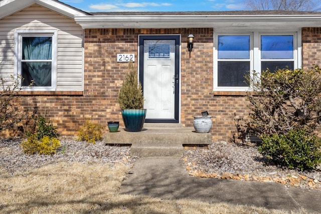 property entrance featuring brick siding