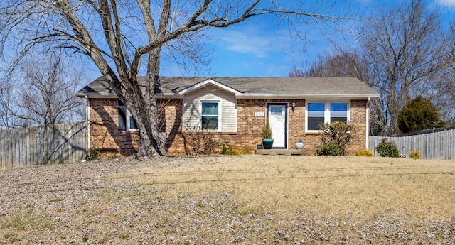 ranch-style home featuring brick siding and fence