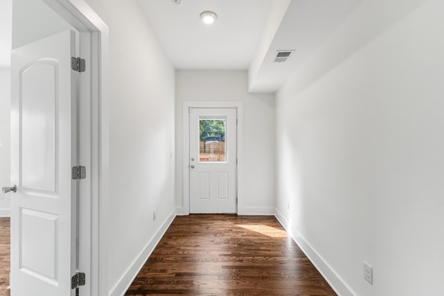 doorway featuring dark wood-type flooring, visible vents, and baseboards