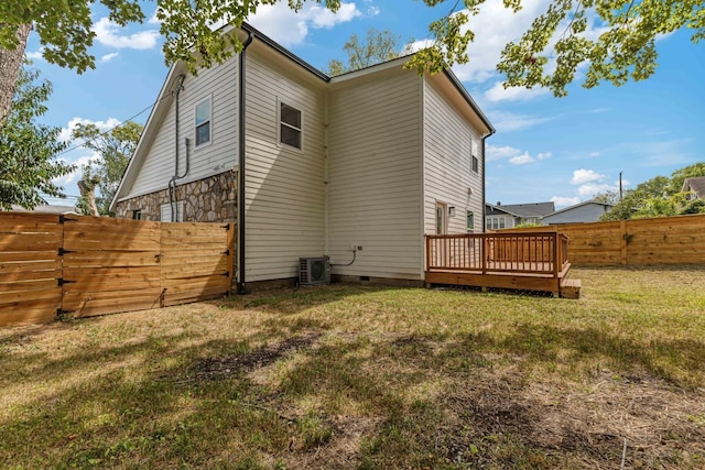 back of house featuring a yard, crawl space, stone siding, a fenced backyard, and a wooden deck