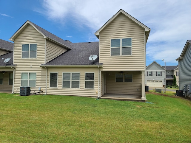 back of property with a patio area, roof with shingles, central AC, and a yard