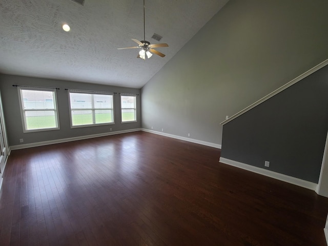 unfurnished living room with dark wood-style floors, visible vents, a textured ceiling, high vaulted ceiling, and baseboards