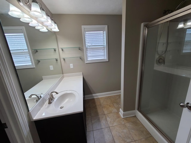 bathroom with plenty of natural light, a shower stall, vanity, and tile patterned floors