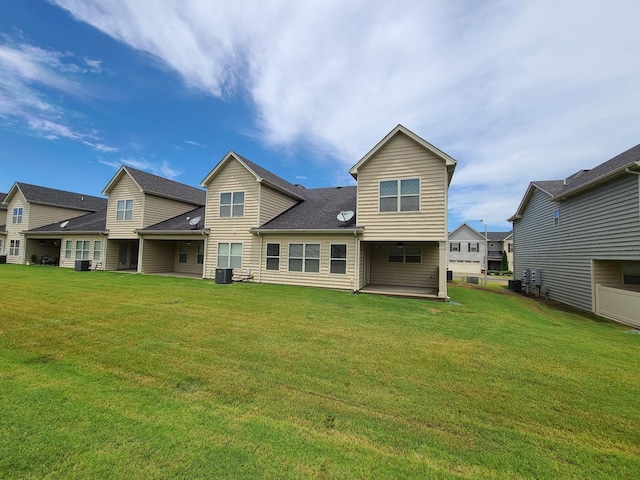 rear view of property with a lawn and central air condition unit