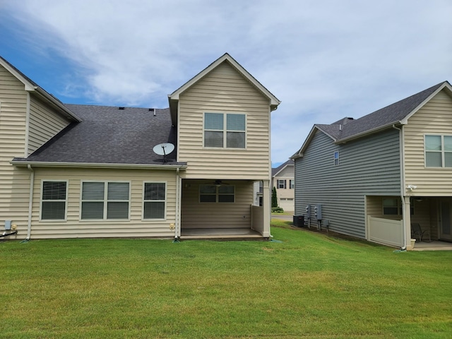 back of property featuring a patio area, roof with shingles, and a yard