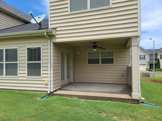 view of exterior entry featuring a patio, a yard, and a ceiling fan