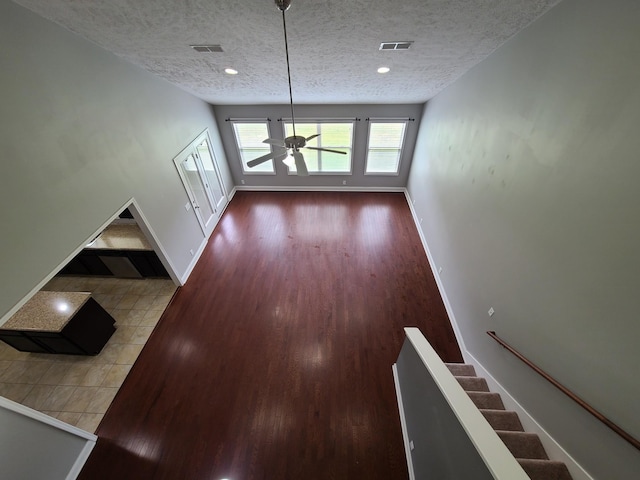 interior space featuring a textured ceiling, visible vents, and baseboards