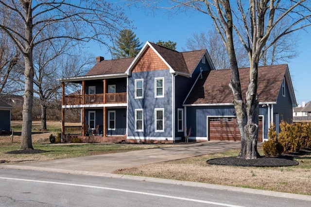 view of front facade featuring roof with shingles, a chimney, a balcony, a garage, and driveway