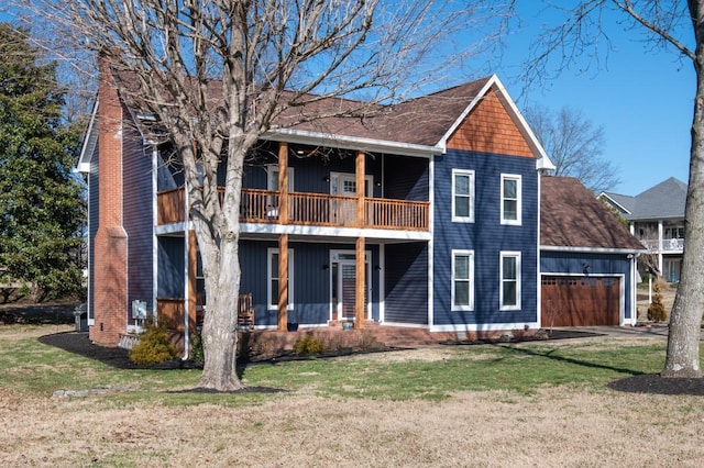 back of house featuring a balcony, a garage, and a yard