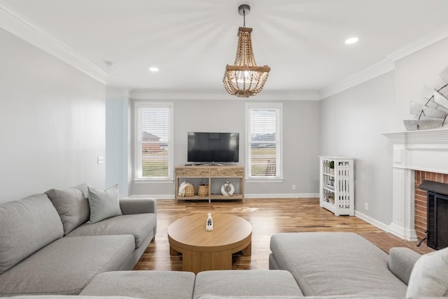 living area with a brick fireplace, baseboards, ornamental molding, and wood finished floors