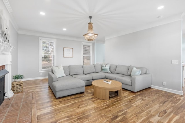 living area with a brick fireplace, baseboards, ornamental molding, and light wood finished floors