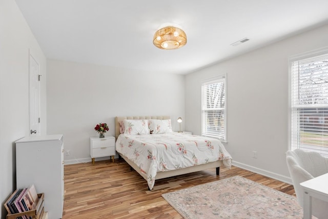 bedroom featuring light wood-style floors, multiple windows, and visible vents