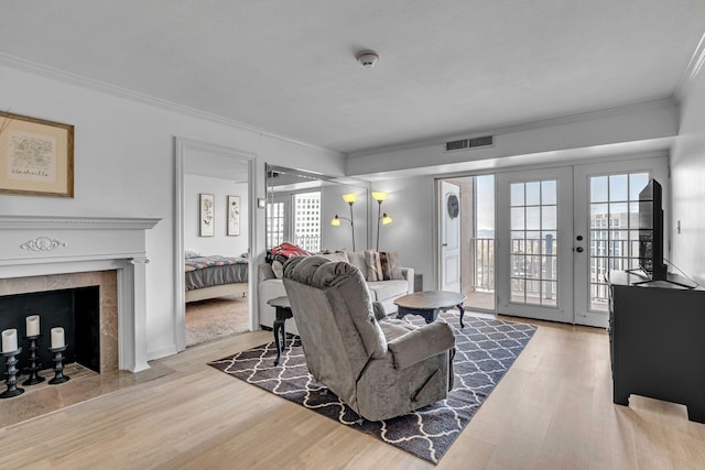 living room featuring visible vents, wood finished floors, french doors, and ornamental molding