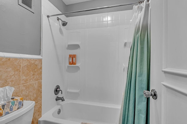 full bathroom with toilet, visible vents, tile walls, and shower / bath combination with curtain