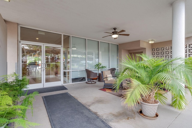 view of exterior entry with a ceiling fan, a patio area, and stucco siding