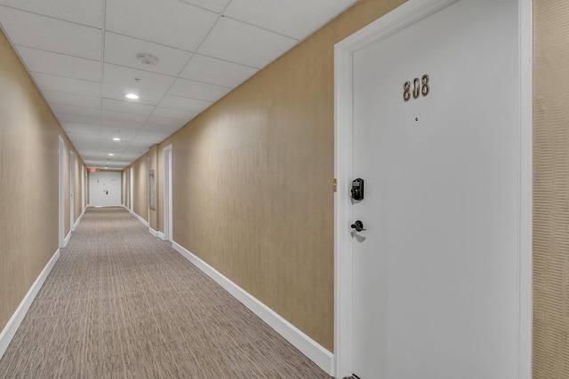 hall featuring recessed lighting, carpet flooring, a paneled ceiling, and baseboards