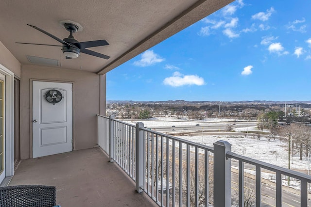 snow covered back of property with ceiling fan