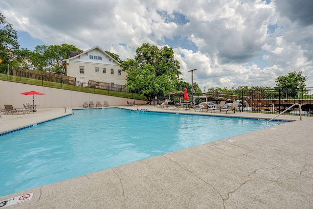 community pool featuring a patio area and fence