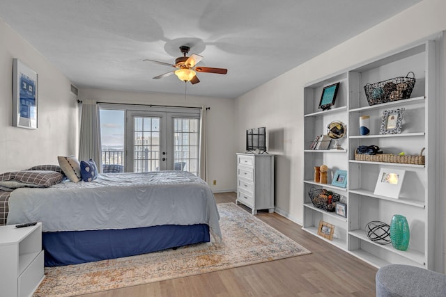 bedroom featuring access to exterior, french doors, ceiling fan, wood finished floors, and baseboards