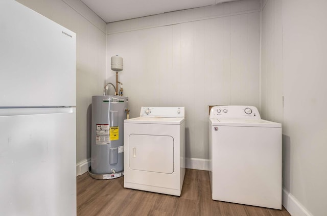 laundry area featuring washer and clothes dryer, electric water heater, wood finished floors, laundry area, and baseboards