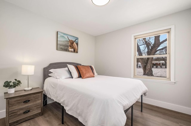 bedroom with wood finished floors and baseboards