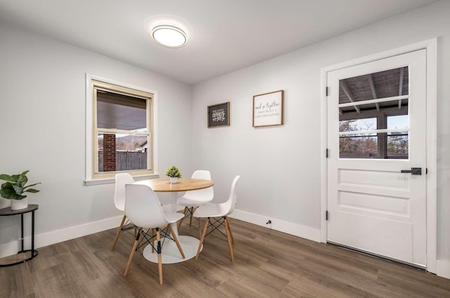 dining space featuring baseboards and dark wood-style flooring