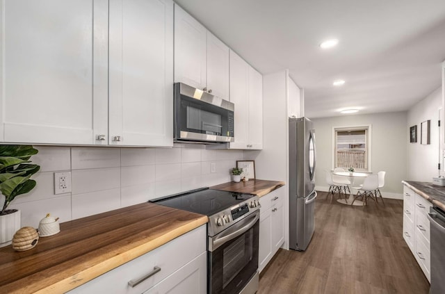 kitchen featuring stainless steel appliances, dark wood-style flooring, white cabinets, and decorative backsplash