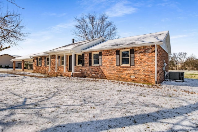 view of front of home featuring covered porch, brick siding, crawl space, and central AC unit