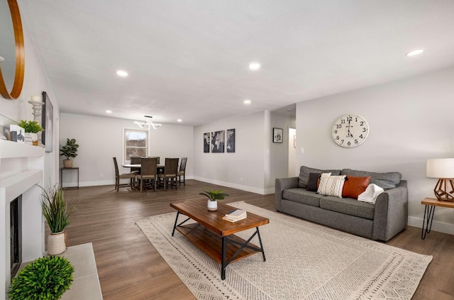 living area with a fireplace, baseboards, wood finished floors, and recessed lighting