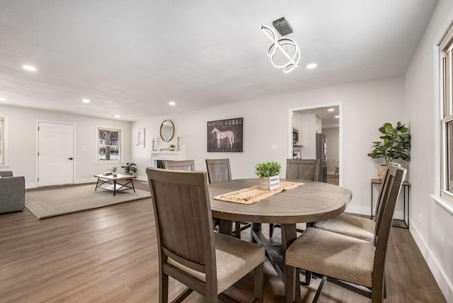 dining room featuring dark wood-type flooring, recessed lighting, a fireplace, and baseboards