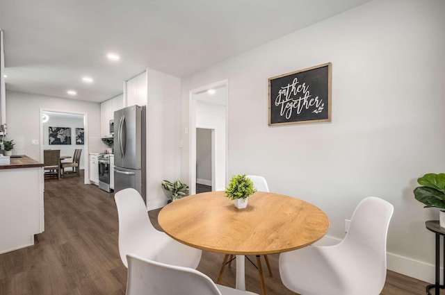 dining space with baseboards, dark wood-type flooring, and recessed lighting